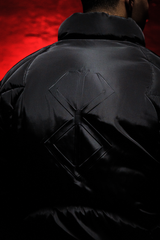 Black Tormented puffer jacket with a geometric pattern on the back against a red background